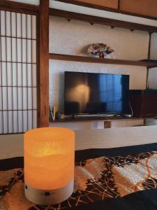 uma sala de estar com uma grande televisão e uma mesa em 温泉付きの一軒家を借りよう em Beppu