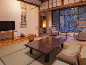 松本市にある白骨温泉　お宿つるやのテーブルとテレビのあるリビングルーム