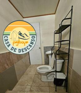 a bathroom with a toilet and a sign on the wall at Casa de Descanso Pejibaye in Pejibaye
