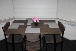 a wooden table with a vase of flowers on it at Awesome Coventry Home from Home for Business Contractors and Suitable for families with Free WI-FI Free Parking in Coventry