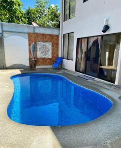 una piscina azul frente a una casa en Casa Playa Bahia Ballena de Osa, en Uvita