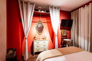 a bedroom with red walls and a bed and a dresser at Apartamento Mikaela Alcalá de Henares in Alcalá de Henares