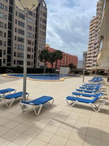 una fila de tumbonas azules en una piscina en Apartment Bahia del Sol, a 20 m de Playa Arinal-Bol,Calpe, en Calpe
