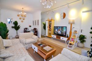 a living room with a couch and a tv at Heaven in Earth in Madinaty