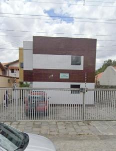 a building with a fence in front of it at Apartamento próximo ao Parque do Povo em Campina Grande in Campina Grande