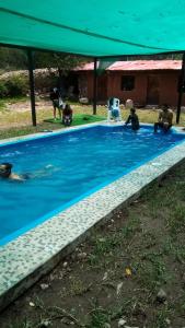 a group of people sitting around a swimming pool at Eco Lodge Cabañas con Piscina in Urubamba