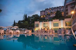 フンシャルにあるReid's Palace, A Belmond Hotel, Madeiraのプールの周りに座る人々