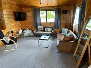uma sala de estar com sofás e uma televisão numa cabana em Hartlock in Onetangi em Onetangi