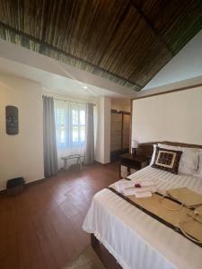 a bedroom with a bed and a desk and a window at San Nicolas Private Beach in Busuanga