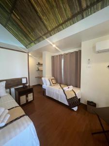 um quarto com 2 camas e piso em madeira em San Nicolas Private Beach em Busuanga