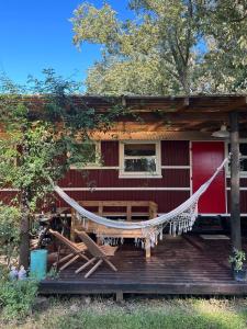 a hammock in front of a red house at Salida de las Casillas in Ingeniero Maschwitz