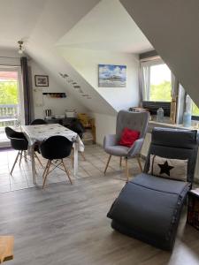 a living room with chairs and a table and a couch at Haus Herrenmühle Fewo OG 2 in Garding