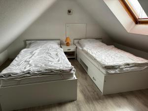two twin beds in a attic bedroom with a mirror at Haus Herrenmühle Fewo OG 2 in Garding