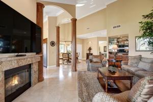 a living room with a fireplace and a tv at VB944 - Triple Fairway View - Palm Valley CC in Palm Desert