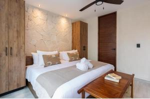 a bedroom with a large bed and a wooden table at JADE ZEN RESIDENCES - (35) in Tulum +26 photos