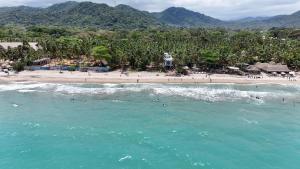 an aerial view of a beach with people in the water at Makao Beach Hotel in Palomino
