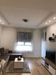 a living room with a couch and a television at Apartment TAJM in Trebinje