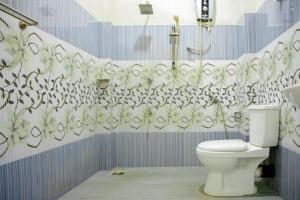 y baño con aseo y cortina de ducha. en New Cormorant Lake Resort & Yala Safari Place en Tissamaharama