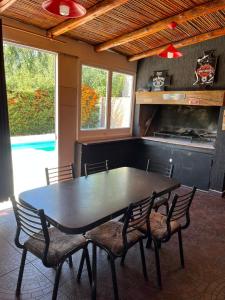 a dining room with a black table and chairs at Tu rincón la travesia in Las Compuertas