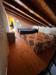 a bedroom with a large bed and a wooden floor at Tu rincón la travesia in Las Compuertas