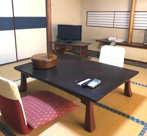 a black coffee table in a room with a tv at Izuya Ryokan - Vacation STAY 49545v in Miyakami