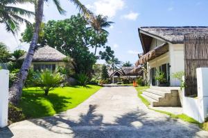 a driveway leading to a house with palm trees at Ikani Surf Resort in Pagudpud