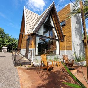 uma casa com duas cadeiras e um edifício em AriMara Chalés & Ecoturismo em Praia Grande