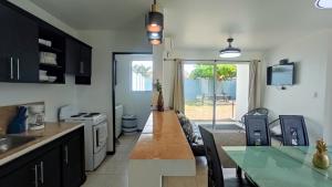 cocina con mesa y comedor en Beachside Bliss: Shared Pool, BBQ -Close to beach!, en Bejuco