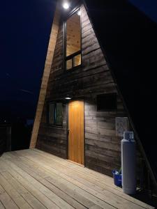 uma casa de madeira com uma porta de madeira num deque em Cabaña El Respiro em El Diamante