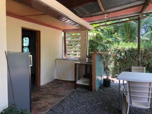 an outside patio with a table and a refrigerator at CABINA EL MANU in Golfito