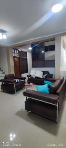 una sala de estar con sofás y mesas. en casa sol residencial, en Tarapoto
