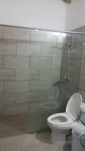 a bathroom with a toilet and a glass shower stall at Splendid 3 Bedroom House with Terrace -Near Utesa in Santiago de los Caballeros