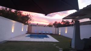 ゴドイ・クルスにあるAires Andinosの椅子付きのプールと夕日のある裏庭