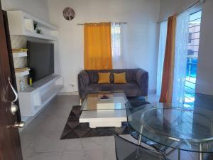 Splendid 3 Bedroom House with Terrace -Near Utesa في سانتياغو دي لوس كاباليروس: غرفة معيشة مع أريكة وطاولة زجاجية