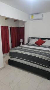 Splendid 3 Bedroom House with Terrace -Near Utesa في سانتياغو دي لوس كاباليروس: غرفة نوم بسرير كبير مع ستائر حمراء