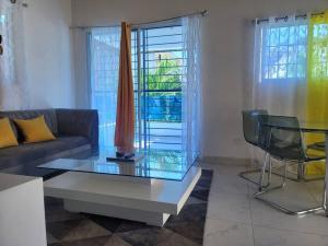 a living room with a couch and a glass table at Splendid 3 Bedroom House with Terrace -Near Utesa in Santiago de los Caballeros