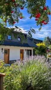 una casa con flores delante en Las Piedras en San Martín de los Andes