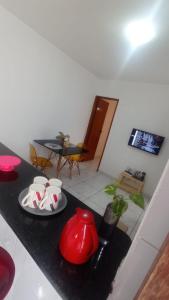 a living room with a table with a red vase on a counter at Casa em João Pessoa Paraíba in João Pessoa