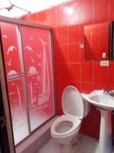 a red bathroom with a toilet and a sink at nice house in Ecuadorian Amazonia in Tena