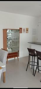 a room with a glass display case with two chairs at RED DESIGN - Apto completo 2 Qts 901 in Vitória