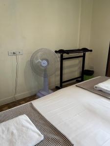 Samsen Sam Place في بانكوك: غرفة نوم مع مروحة بيضاء بجوار سرير
