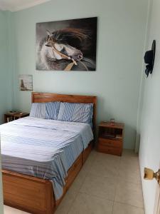 a bedroom with a bed with a painting on the wall at Casa de playa in Machalilla