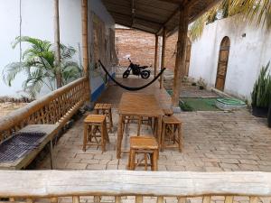 a wooden table and stools on a patio with a motorcycle at Casa de playa in Machalilla