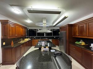 メデジンにあるLuxurytravelhome millionairesの広いキッチン(黒いカウンタートップ、木製キャビネット付)