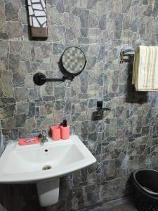 baño con lavabo y espejo en la pared en Bungalow with Private Gym and Car park, en Chennai