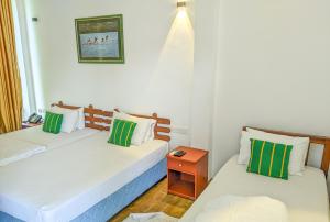 two twin beds in a room with a night stand at Yala Golden Wild in Tissamaharama +50 photos