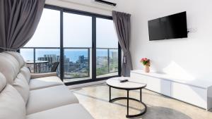 uma sala de estar com mobiliário branco e janelas grandes em AIR APARTMENTS Residence - Sihanoukville - 400m to boat pier em Sihanoukville