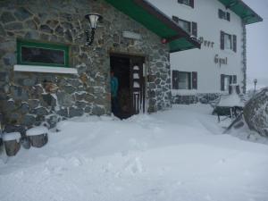 un patio cubierto de nieve frente a un edificio en Peer Gynt Ski Lodge, en Perisher Valley