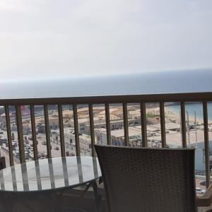 Luxury furnished apartment للعائلات فقط overlooking the sea في الإسكندرية: طاولة وكرسي على شرفة مطلة على الشاطئ