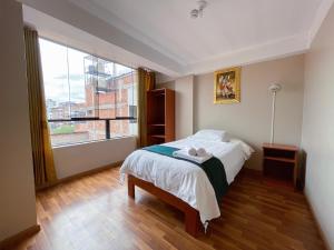 - une chambre avec un lit et une grande fenêtre dans l'établissement Hotel Rituales Inn - terminal terrestre, à Cusco